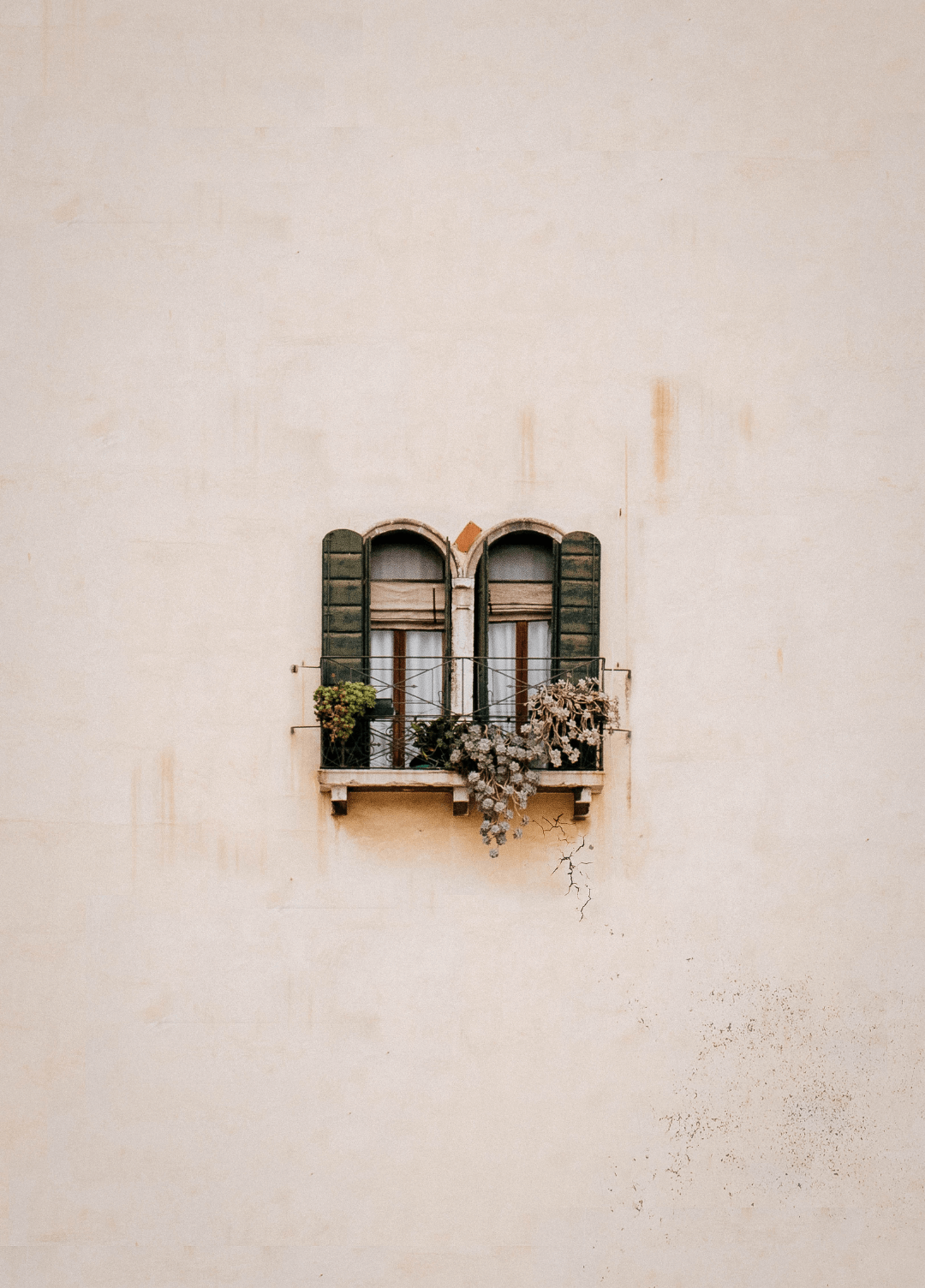 Window with shutters on a beige outside wall