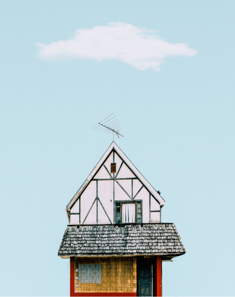 Top of a quirky house with a blue sky
